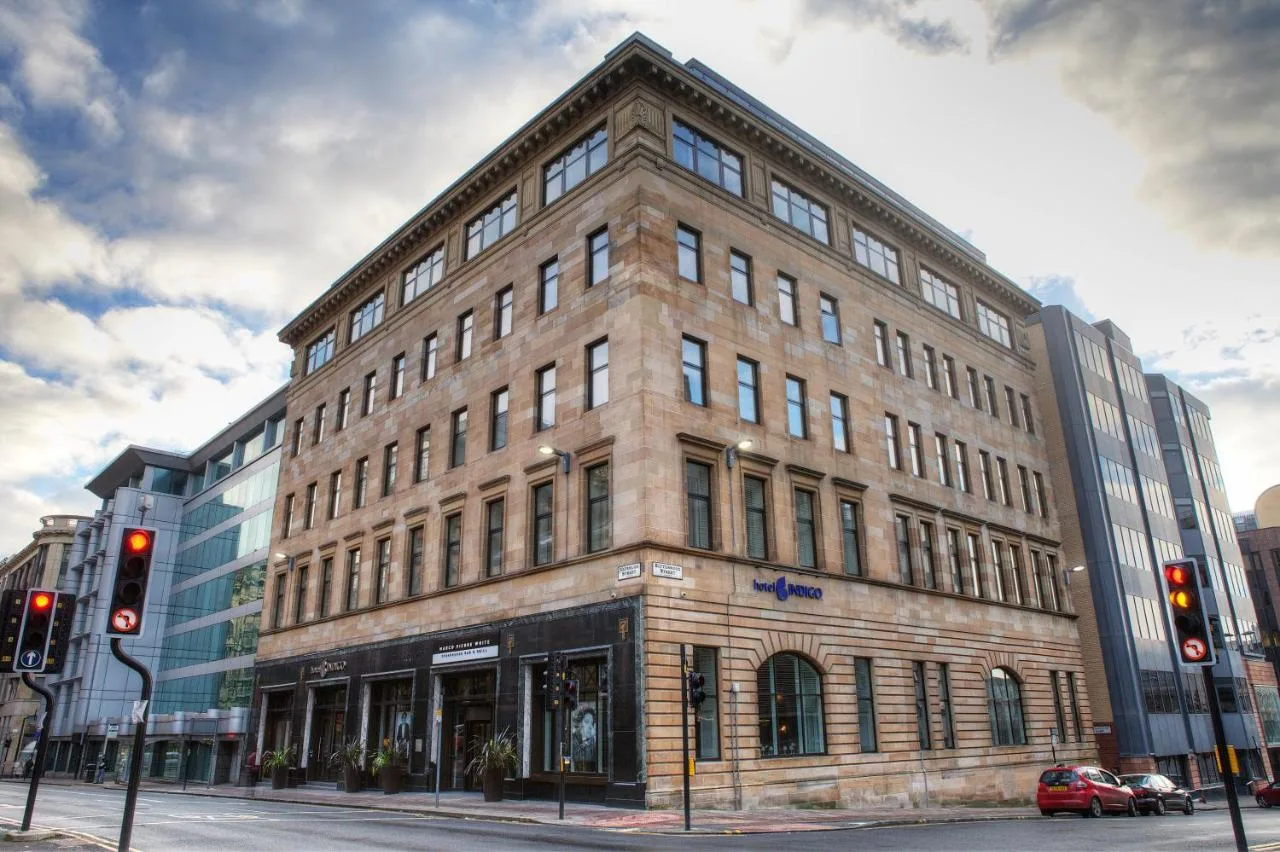 a large brick building on a city street with traffic lights at Hotel Indigo Glasgow by IHG in Glasgow
