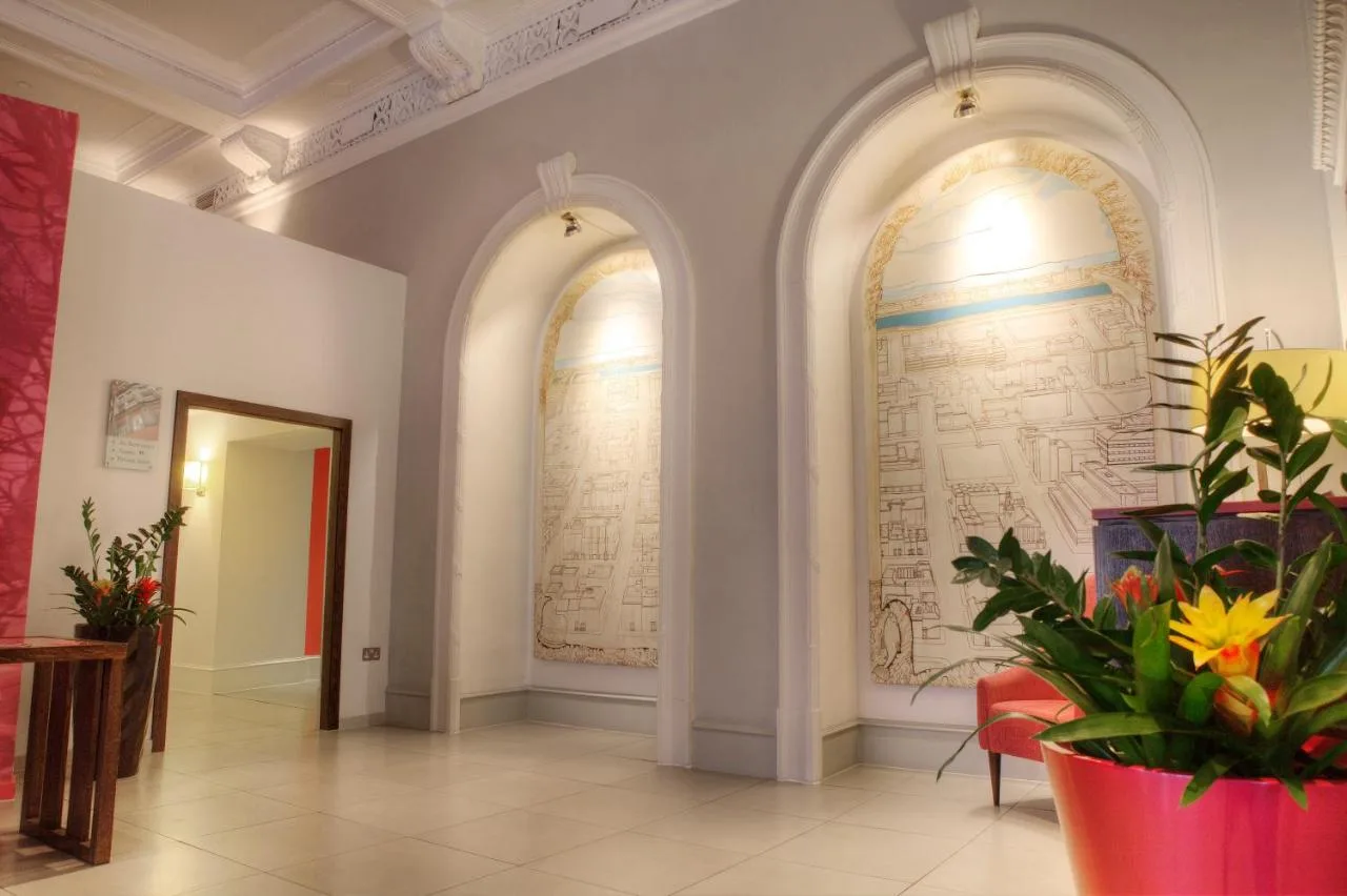 a hallway with two arched windows and a large wall at Hotel Indigo Glasgow by IHG in Glasgow